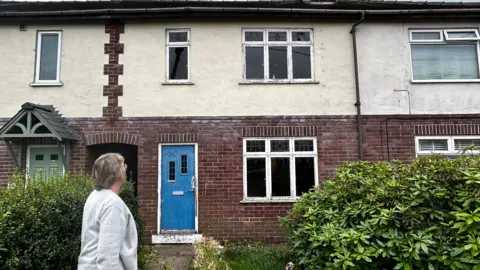 BBC A terraced brick house in Knaresborough with a blue front door
