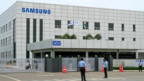 Getty Images Security personnel stand guard at Samsung India's plant in Sriperumbudur, near Chennai on September 11, 2024, as workers stage a protest to demand higher wages and recognition of their union. Samsung Electronics workers in southern India went on strike from September 9 to demand better pay and working hours, with the consumer tech giant promising the industrial action would not impact consumers. (Photo by R.Satish BABU / AFP) (Photo by R.SATISH BABU/AFP via Getty Images)