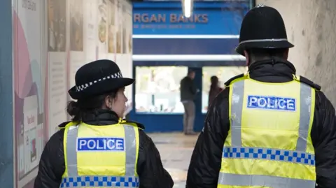 Cumbria Police Two police officers walk down a corridor