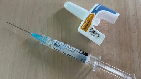 Julia Gregory/BBC A syringe and a nasal spray containing naloxone, which is an antidote to opiod overdoses