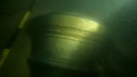 Steven Ellis The barrel or shot end of a 17th Century gun or cannon appearing through the murky water of the Thames Estuary