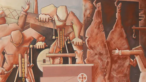 Shafik Meghji Workers from more than 60 countries were drawn by jobs provided by Fray Bentos' meat processing factory, depicted here in a mural by Angel Juárez Masares (Credit: Shafik Meghji)