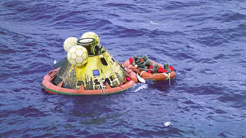 Nasa The three astronauts plus a diver wait to be picked up, after opening the capsule (Credit: Nasa)