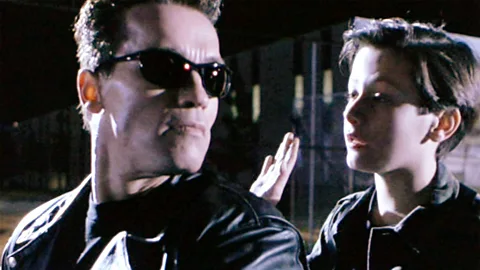 Getty Images In the 1991 sequel, Terminator 2: Judgment Day, the T-800 (Arnold Schwarzenegger) protects John Connor (Edward Furlong) (Credit: Getty Images)