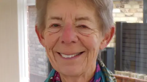 Judith Boichot A smiling Judith Boichot. She has grey hair and is wearing a multicoloured scarf.