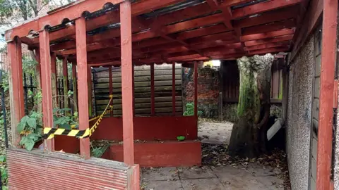 Rippleacts An outdoor space, with wooden structure, with leaves, a tree, a taped off area and