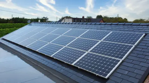 Microgeneration Certification Scheme A set of 24 solar panels which have been fitted onto a roof at a home.