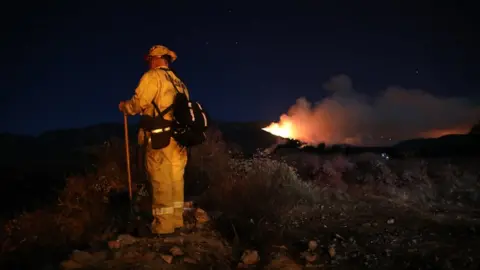 EPA A firefighter battles the "Apple Fire" near Beaumont in Riverside County, California