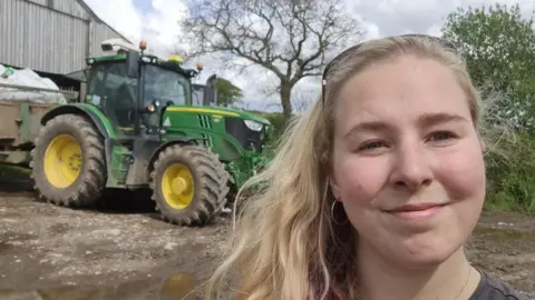 Abi Irwin woman in front of tractor