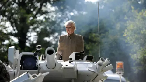 Andrew Matthews/PA Media Anti-fracking campaigner Dame Vivienne Westwood, sits in a tank as she joins a group of anti-fracking protesters, 2015
