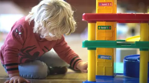 Getty Images A young boy plays with toys at a playgroup for pre-school aged children in 2015.