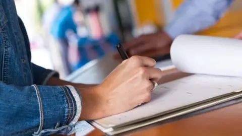 Getty Images Woman signs document